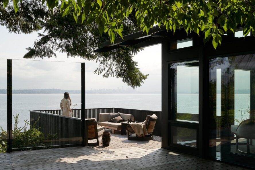 A wood deck with a person standing and looking out on the Puget Sound.