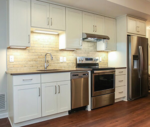new white kitchen cabinets with overhead lighting and appliances